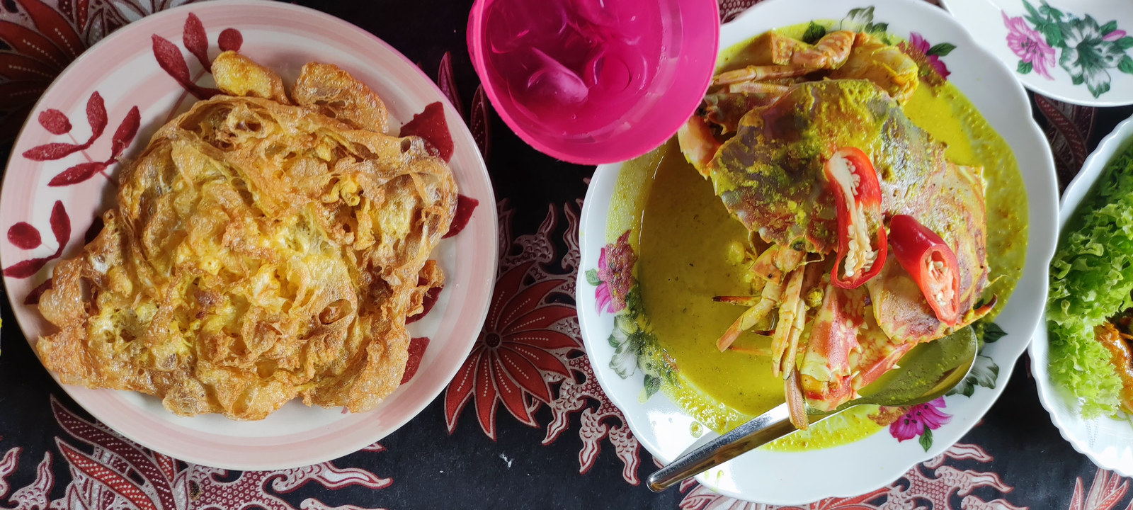 Crab in yellow coconut gravy beside a large omelette.